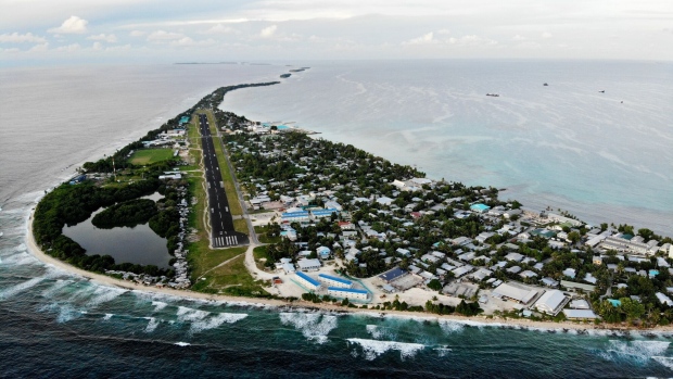 FUNAFUTI, TUVALU - NOVEMBER 28: An aerial view of downtown and the airport runway, between the Pacific Ocean (L) and lagoon (R), on November 28, 2019 in Funafuti, Tuvalu. The low-lying South Pacific island nation of about 11,000 people has been classified as ‘extremely vulnerable’ to climate change by the United Nations Development Programme. The world’s fourth-smallest country is struggling to cope with climate change related impacts including five millimeter per year sea level rise (above the global average), tidal and wave driven flooding, storm surges, rising temperatures, saltwater intrusion and coastal erosion on its nine coral atolls and islands, the highest of which rises about 15 feet above sea level. In addition, the severity of cyclones and droughts in the Pacific Island region are forecast to increase due to global warming. Some scientists have predicted that Tuvalu could become inundated and uninhabitable in 50 to 100 years or less if sea level rise continues. The country is working toward a goal of 100 percent renewable power generation by 2025 in an effort to curb pollution and set an example for larger nations. Tuvalu is also exploring a plan to build an artificial island. (Photo by Mario Tama/Getty Images)