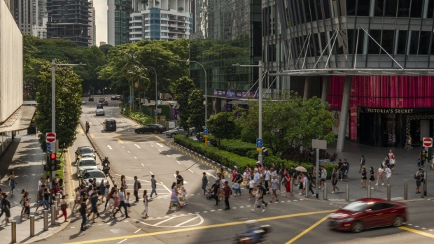 Pedestrians cross a road on Orchard Road in Singapore, on Monday, Nov. 20, 2023. Singapore's gross domestic product figures for the third quarter are scheduled to be released on Nov. 22. Photographer: Lauryn Ishak/Bloomberg