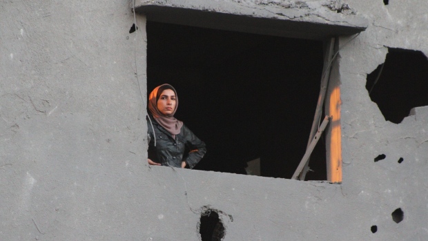<p>A Palestinian woman looks out from the window of a damaged building following an Israeli airstrike in the Nuseirat refugee camp, central Gaza, on Wednesday, Feb. 28, 2024. A program to provide temporary residency to Gazans with family in Canada isn’t working because they can’t get out of the war-torn region,  Canadian Immigration Minister Marc Miller said. </p>