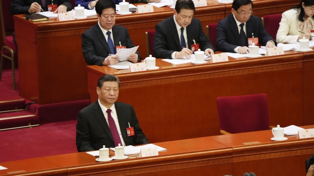 Xi Jinping, China's president, left, listens as Li Qiang, China's premier, not pictured, speaks during the opening of the Second Session of the 14th National People's Congress (NPC) at the Great Hall of the People in Beijing, China, on Tuesday, March 5, 2024. China will set its growth target at around 5% for the year, according to a copy of the government’s annual work report seen by Bloomberg News, raising expectations for officials to unleash more stimulus as they try to lift confidence in a slowing economy. Photographer: Qilai Shen/Bloomberg
