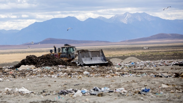 <p>A bulldozer moves trash at a landfill refuse site.</p>