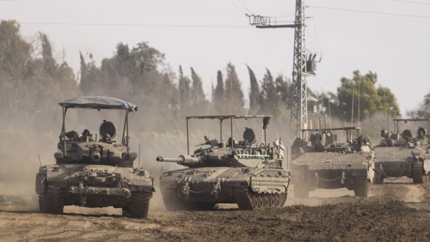 Israeli forces travel towards Gaza in tanks and armored vehicles, viewed near the Israel-Gaza border in southern Israel, on Jan. 24. Photographer: Kobi Wolf/Bloomberg