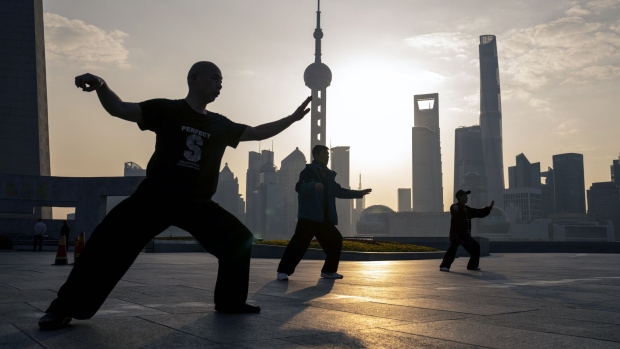 People practice tai chi in front of buildings in Pudong's Lujiazui Financial District in Shanghai, China, on Monday, Feb. 19, 2024. Chinese stocks saw modest gains as onshore traders returned from the Lunar New Year holidays, with broader caution toward the market offsetting buoyant travel and spending data. Photographer: Raul Ariano/Bloomberg