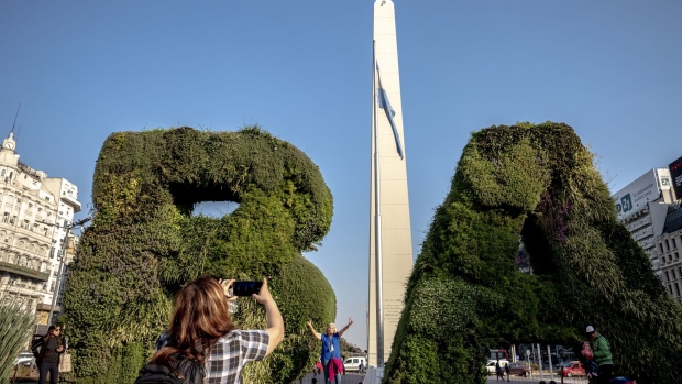 Tourists take photos in front of the Obelisk in Buenos Aires, Argentina, on Wednesday, Aug. 24, 2022.