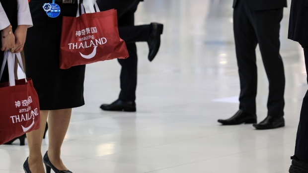 Staff members hold bags reading "Amazing Thailand" during an event to welcome inbound tourists from China at Suvarnabhumi Airport in Bangkok, Thailand, on Monday, Sept. 25, 2023. Thailand agreed to waive visa requirements for travelers from China and Kazakhstan for five months starting Sept. 25 as the tourism-reliant nation turns to the travel industry to prop up Southeast Asia’s second-largest economy. Photographer: Valeria Mongelli/Bloomberg
