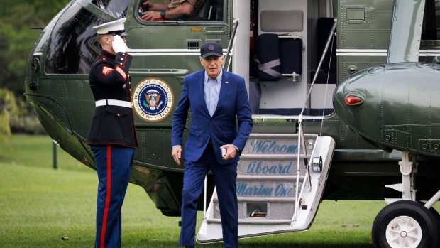 US President Joe Biden, right, walks on the South Lawn of the White House after arriving on Marine One in Washington, DC, US, on Wednesday, April 17, 2024. The Biden administration reimposed oil sanctions on Venezuela, ending a six-month reprieve, after determining that Nicolas Maduro's regime failed to honor an agreement to allow a fairer vote in elections scheduled for July. Photographer: Ting Shen/Bloomberg