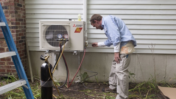 A worker installs a heat pump at a home in Standish, Maine. Photographer: Brianna Soukup/Portland Press Herald/Getty Images