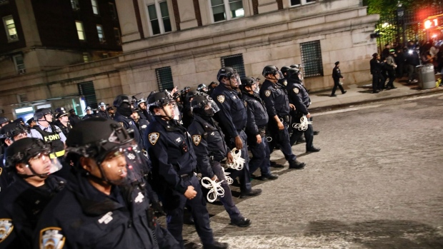 NYPD officers in riot gear march onto Columbia University campus on April 30. Photographer: Kena Betancur/AFP/Getty Images