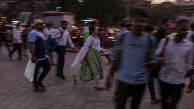 Pedestrians walk towards the Chhatrapati Shivaji Terminus train station at dusk in Mumbai, India. Photographer: Dhiraj Singh/Bloomberg
