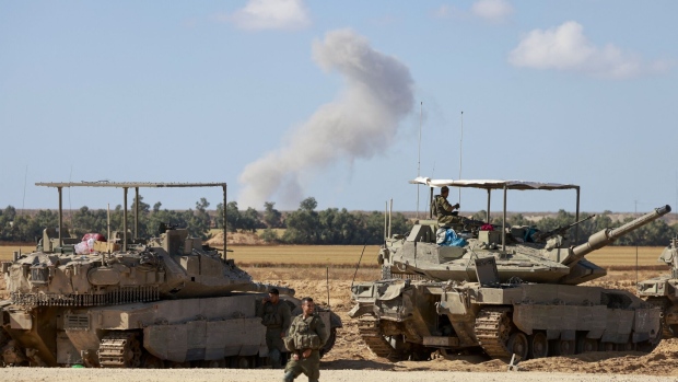 Israeli army tanks take position near the border with Gaza as smoke billows during an Israeli bombardment on May 6. Photographer: Menahem Kahana/AFP/Getty Images