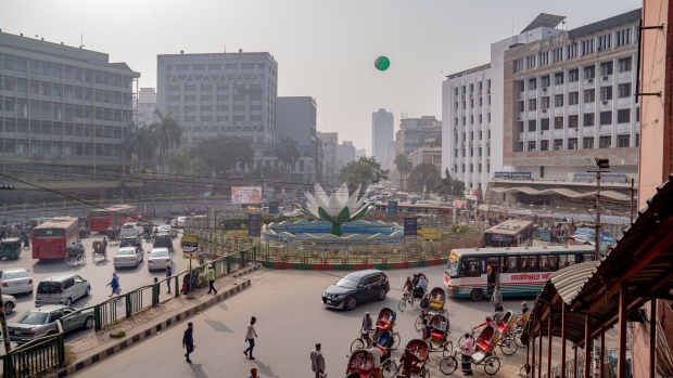 <p>Vehicles travel along a road in Dhaka, Bangladesh.</p>