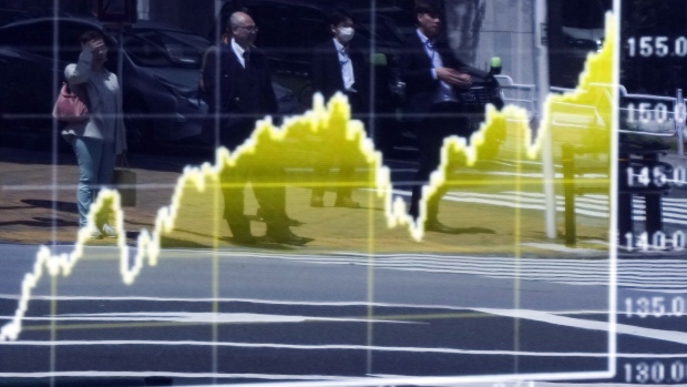 Pedestrians reflected in an electronic board displaying a graph of the exchange rate of the yen against the U.S. dollar outside a securities firm in Tokyo, Japan, on Thursday, May 2, 2024. Fresh data on the Federal Reserve's various accounts hints at two potential ways Japanese policy makers may have funded currency interventions this past week to bolster the beleaguered yen. Photographer: Toru Hanai/Bloomberg