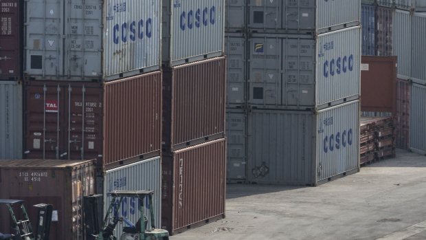 Cosco shipping containers sit on a dock at Victoria Harbor in Hong Kong. Photographer: Jerome Favre/Bloomberg