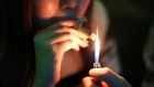 <p>A customer lights up a joint inside a cannabis dispensary in Bangkok.</p>