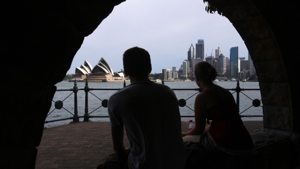 A couple view the Sydney Opera House and city skyline in Sydney, Australia. Photographer: Sergio Dionisio/Bloomberg