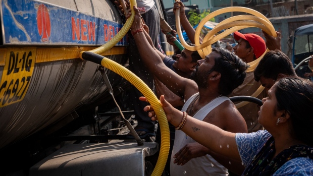 <p>People gather around a municipal tanker to collect water during high temperatures in New Delhi, India on May 18.</p>