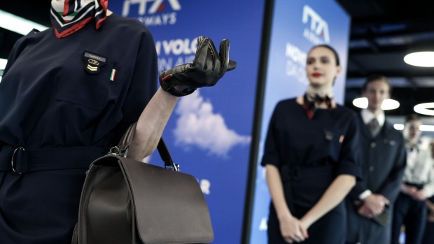 Cabin crew members wear uniforms designed by Brunello Cucinelli during the launch of a new Airbus A320neo aircraft, operated by ITA Airways, at Fiumicino airport in Rome, in 2023. Photographer: Alessia Pierdomenico/Bloomberg  