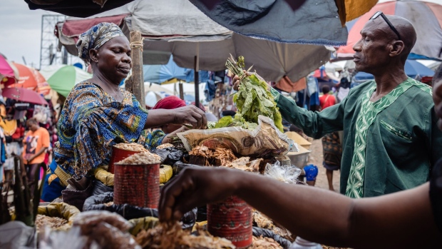 <p>A trader sells fresh produce to customers at Yaba market in Lagos.</p>