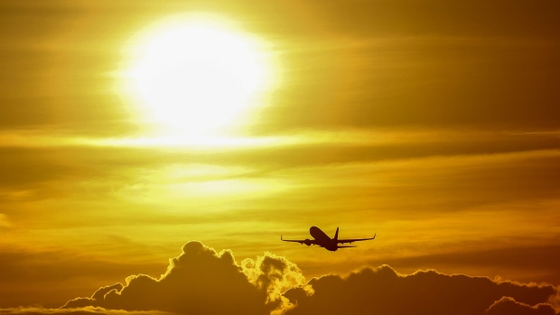 A passenger aircraft flies at sunset from Frankfurt Airport in Germany. Photographer: Bloomberg Creative Photos/Bloomberg
