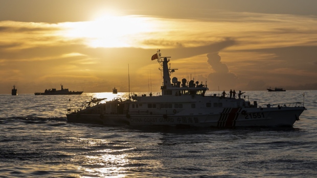 China Coast Guard ships along with other Chinese fishing vessel, which Manila calls maritime militia vessel, during a resupply mission for the BRP Sierra Madre, in the Second Thomas Shoal in the disputed South China Sea, on Friday, Nov. 10, 2023. Both China and the Philippines lay claims over the shoal while at least three other neighbors also claim the larger Spratly Islands chain it nestles in. Photographer: Lisa Marie David/Bloomberg