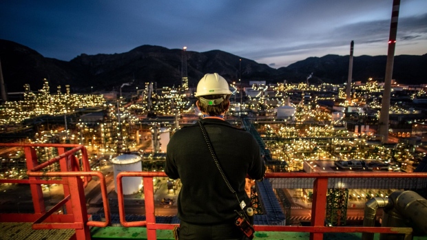 <p>An employee looks out over an oil refining complex in Cartagena, Spain.</p>