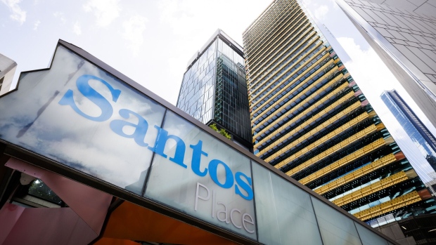 The Santos Ltd. logo displayed at an entrance of Santos Place building, which houses the company's office, in Brisbane, Australia, on Monday, Dec. 11, 2023. Woodside Energy Group Ltd.’s hopes of a tie-up with Santos to create Asia’s dominant liquefied natural gas exporter face a potential hurdle over the valuation of a target whose shares recently fell to an eight-month low. Photographer: Ian Waldie/Bloomberg
