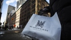 A woman holds a Hudson's Bay shopping bag in front of the HBC flagship department store in Toronto